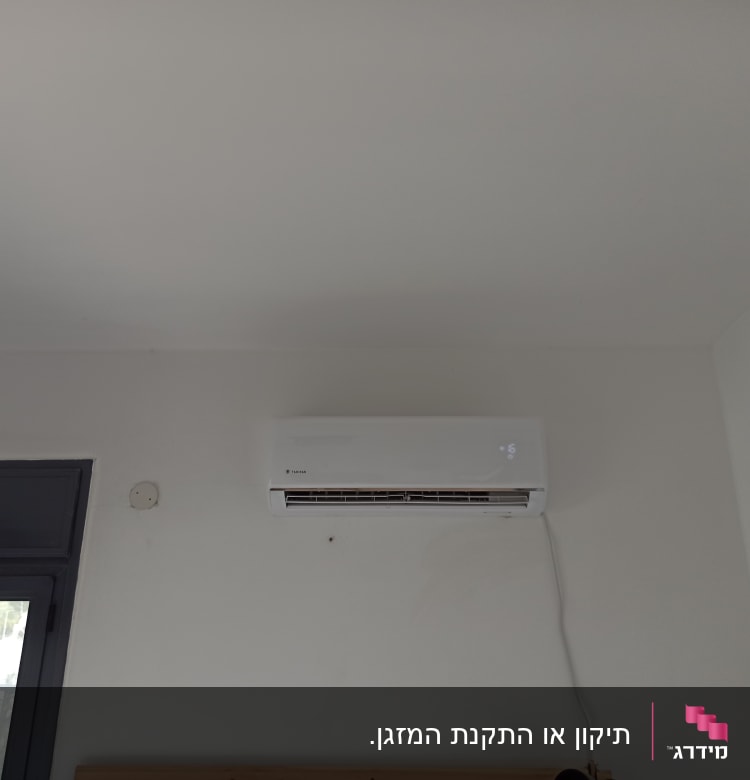 מזגן מותקן על קיר לבן עם תצוגה דיגיטלית